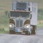 Brown cabover with trailer on the rode